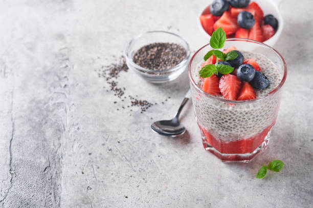 istock Chia strawberry pudding. Healthy vegan breakfast chia seeds pudding with fresh berries and mint in glass on gray concrete background. Concept of healthy eating, dieting, fitness menu. Selective focus. 1410687379