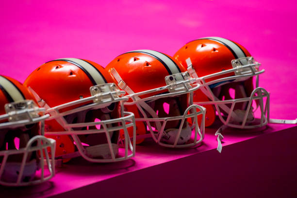 american football players helmets on pink background isolated without people .sport team protection concept. stock photo