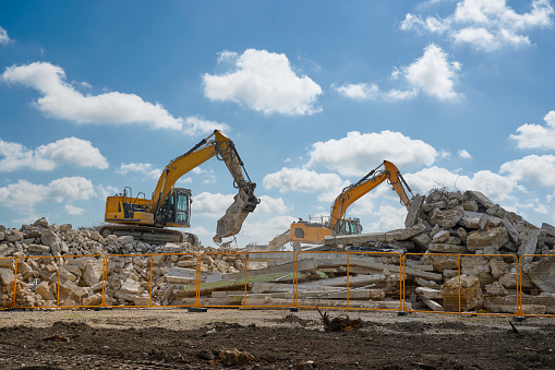 Contractor machines in the process of demolishing old buildings for circular recycling