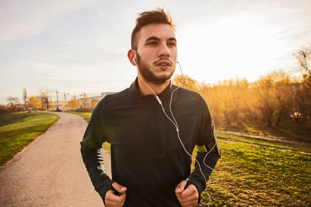 istock Young man runner athlete running in a park wearing headphones 1410690475