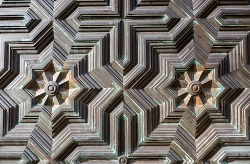 Hypnotizing geometrics forms at the metallic door in a church.