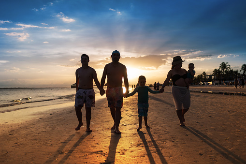Latin family walking on the beach at sunset in Ft Myers Florida