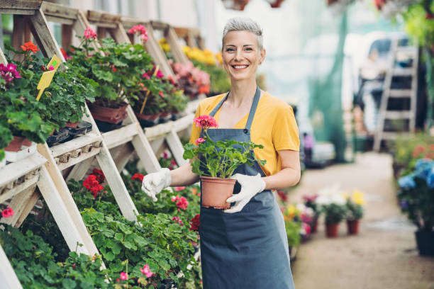 Cheerful gardener working in a garden center stock photo
