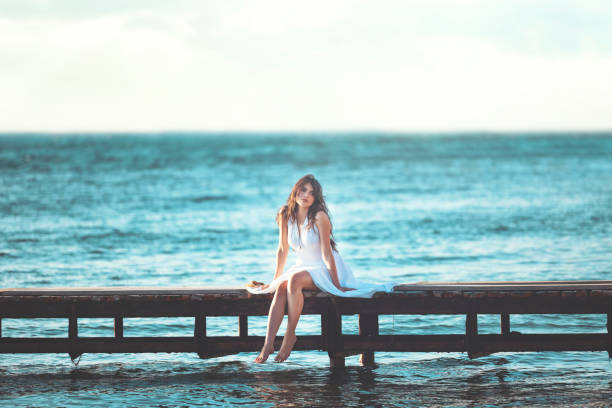 Free Stock Photo of Young woman sits on a wooden bridge with a ...