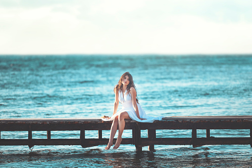 Young woman have fun on the beach with white summer dress. Beauty concept, health care concept, summer time