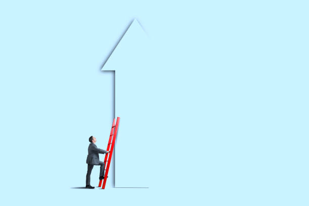 istock Man Leaning Ladder Against Tall Arrow 1410696928