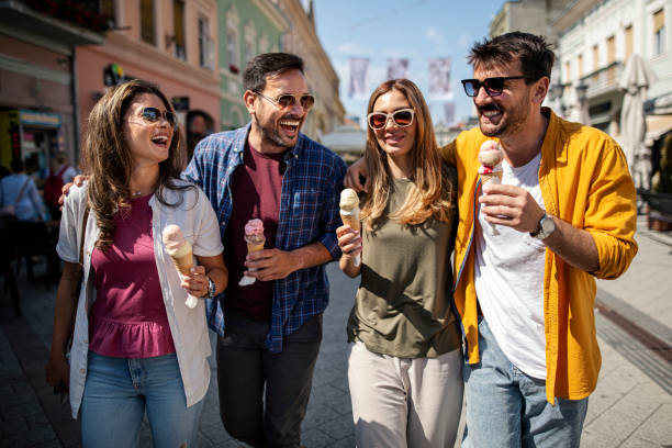 istock Cheerful friends eating ice cream and walking 1410700647