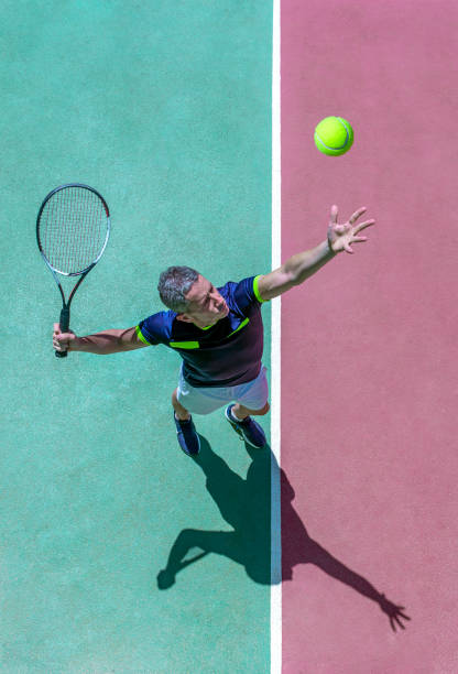 テニスの試合中にコートで奉仕するテニス選手。オーバーヘッドショット。トップビュー。 - tennis serving men court ストックフォトと画像