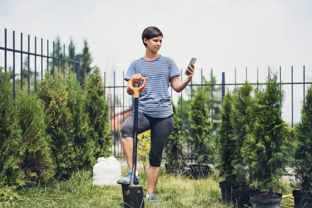 istock Woman checking data of her phone while working in the garden 1410703299