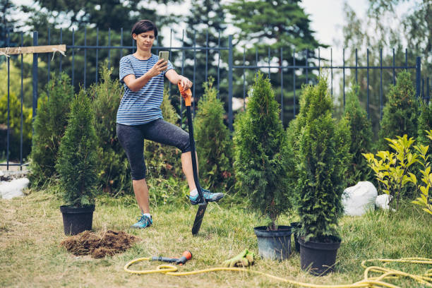 Female gardener taking a break to check phone data