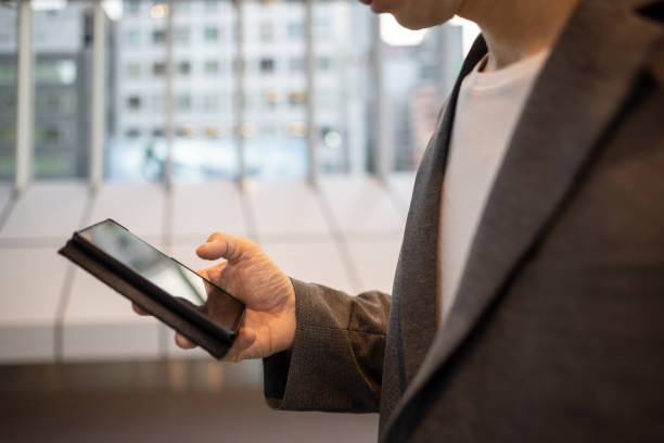 istock Freelance worker standing and looking at screen on smart phone in city 1410705685