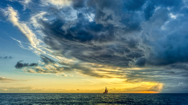 istock Sunset Sailboat Storm Looming Ocean Clouds 1410707496
