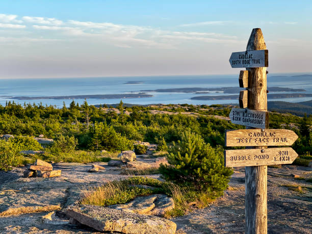 Trail sign along the South Ridge Trail at top of Cadillac Mountain in Maine Directional sign overlooks the ocean in Bar Harbor from the top of Cadillac Mountain in Acadia National Park. acadia national park maine stock pictures, royalty-free photos & images