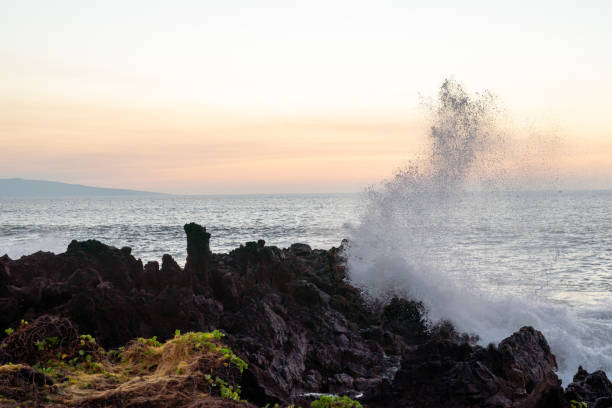 istock Ocean waves crashing on rocks at sunset 1410713537