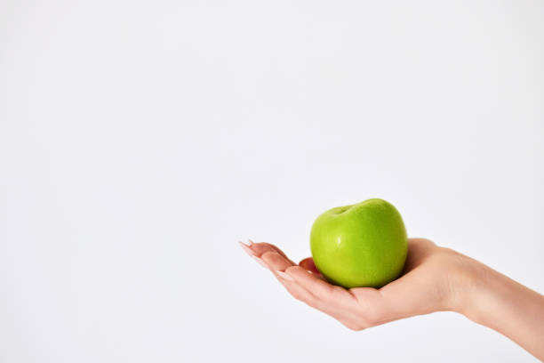 istock female hand holding red apple on white background 1410714046