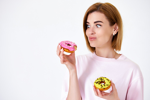 funny beautiful blonde woman with donuts isolated on white background.