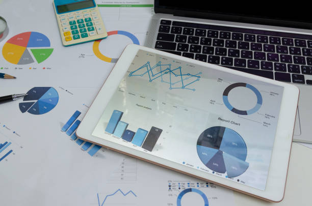 istock Document paperwork graph and chart at tablet with computer laptop and pen. Business finance analysis report marketing and information investment accounting at office digital technology concept. 1410714108