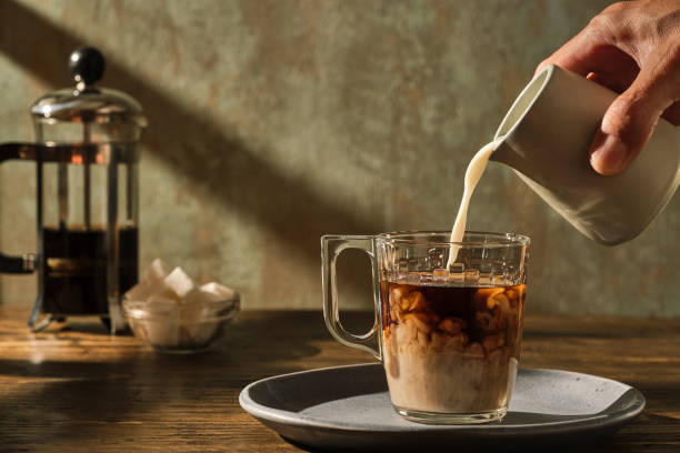 コーヒーにミルクを注ぐ - black coffee ストックフォトと画像