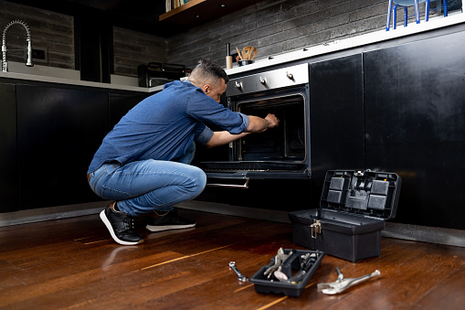 The installing a furniture handle process of assembling kitchen cabinet