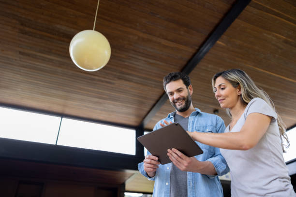istock Couple controlling the lights of their house using an automated system 1410734329