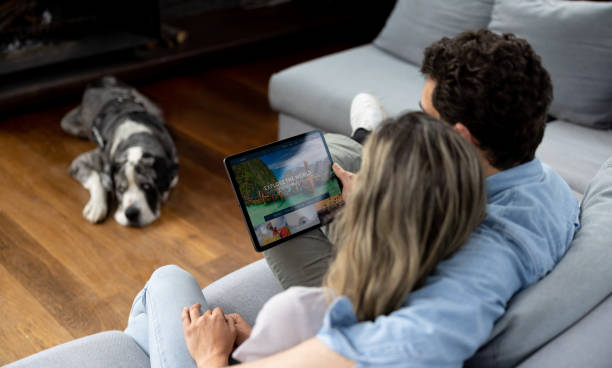 istock Happy couple at home booking a trip online using a tablet 1410734661