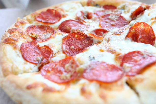 Fresh baked pizza with crusty cheese and hot tasty pepperoni ready to eat