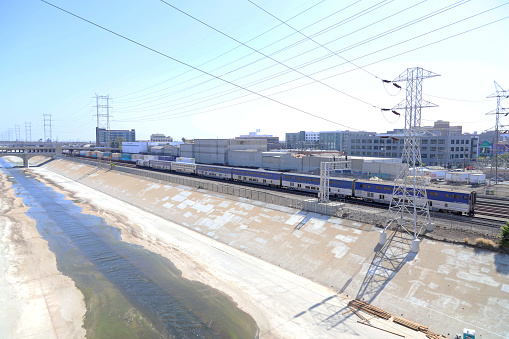 Los Angeles, California, USA -  July 24, 2022: Amtrak Pacific Surfliner train running along Los Angeles River.