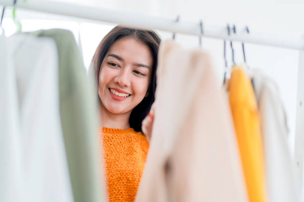 smart schöne asiatische frau genießen hand wählen einkaufen tuch auf kleiderbügel im laden einkaufszentrum, kleinunternehmer fashioned store shop business unternehmer arrangieren tuch auf kleiderbügel im geschäft - autumn women clothing retail stock-fotos und bilder