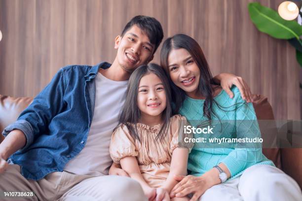 Hand Hello Gesture With Cheerful Smiling Portrait Asian Parent And Daughter Look At Camera Togetherasian Familly Stay Home Together Hand Waving Say Hi On Sofa In Living Room Happy Peaceful Stay Home Stock Photo - Download Image Now