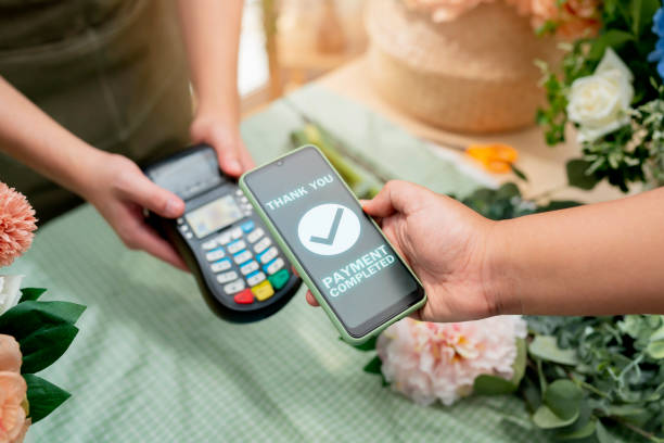 Close up of easy payment by credit card or smartphone application Greenhouse workers selling pottered flowers.Contactless payment with credit card customer at counter using QR code contactless payment primer plano del pago fácil con tarjeta de crédito o aplicación de teléfono inteligente trabajadores de invernadero que venden flores alfareras. pago sin contacto con el cliente de la tarjeta de crédito en el mostrador utilizando el pago sin contacto