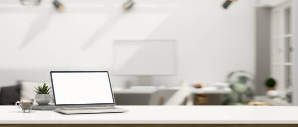 istock White workspace with open laptop mockup and copy space over blurred modern office background 1410741445