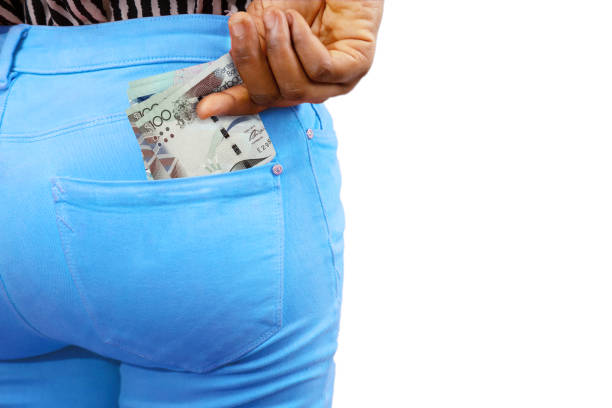 istock lady putting few Barbados dollar notes into her back pocket. Removing money from pocket, hold money, Barbadian dollar 1410742776