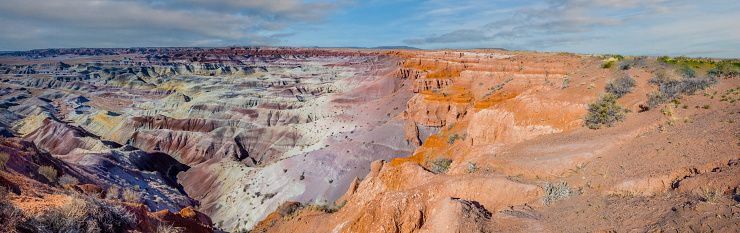 The Painted Desert is an interesting and colorful part of Northern Arizona.  It starts south of Holbrook and extends about 120 miles north almost to the Utah border.  It encompasses about 7,500 square miles of the Colorado Plateau.  The area is made up of colorful mudstone and sandstone known as the Chinle Formation.  The rocks of the Chinle Formation were deposited from 227 to 205 million years ago during the Triassic Period.  Over the next 180 million years the rocks were buried, uplifted and then eroded into the present-day badland topography.  This photograph of the Painted Desert was taken from Little Painted Desert County Park near Winslow, Arizona, USA.