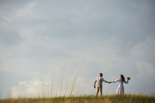 A young couple dancing on top of a hill