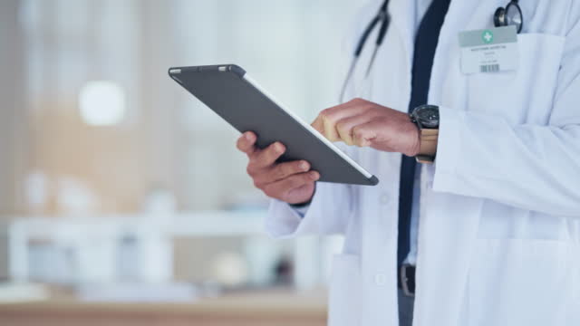 Hands of a doctor sending a digital prescription to a patient online using a tablet. Closeup of a healthcare professional in a hospital, researching the latest breakthrough and innovation in medicine