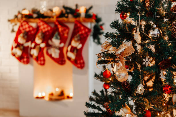 istock Branches of a decorated Christmas tree and a fireplace in the background 1410751701