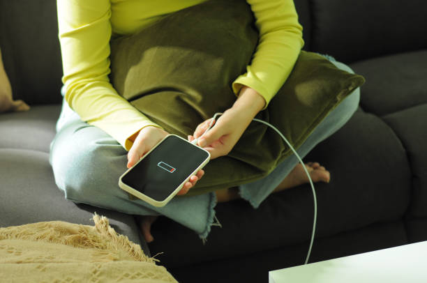 istock Young woman charging mobile phone battery. 1410752246