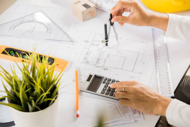 istock Architect drawing with divider compass on house plan blueprint paper 1410753190