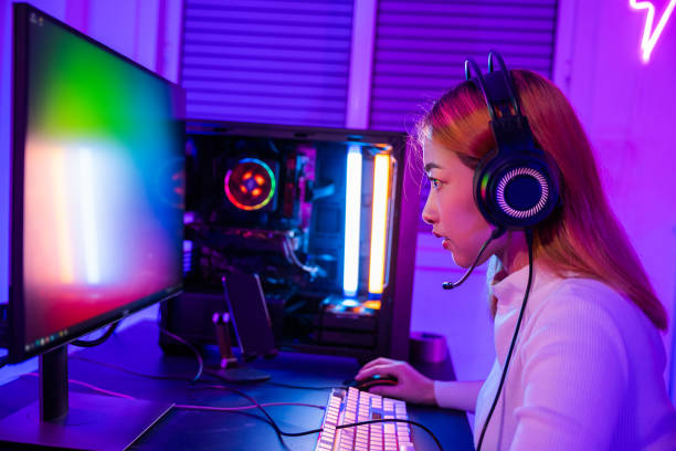 istock Asian professional gamer playing online video game on desktop computer PC have colorful neon LED lights 1410753230