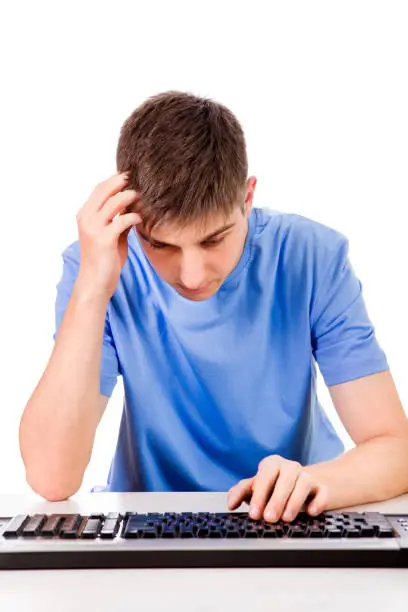 Troubled Young Man with a Computer Keyboard on the White Background
