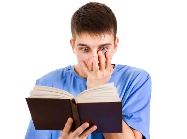 Shocked Young Man read a Book Isolated on the White Background