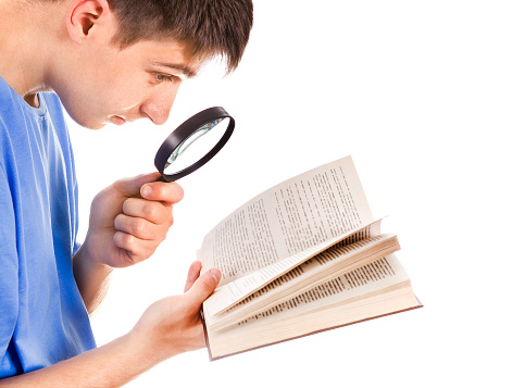 Side View of the Young Man with a Book and Magnifying Glass on the White Background