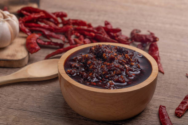 istock Thai spicy chili paste in a wooden cup (nampnikpao) 1410754734