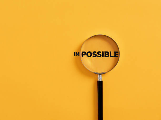 magnifier focuses on the possible side of the word impossible. - possible imagens e fotografias de stock