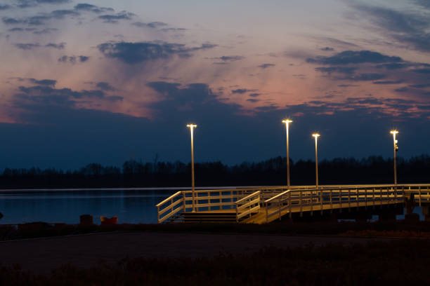 pier on the Serock city beach in the light of a lighthouse before dawn - horizontal shot