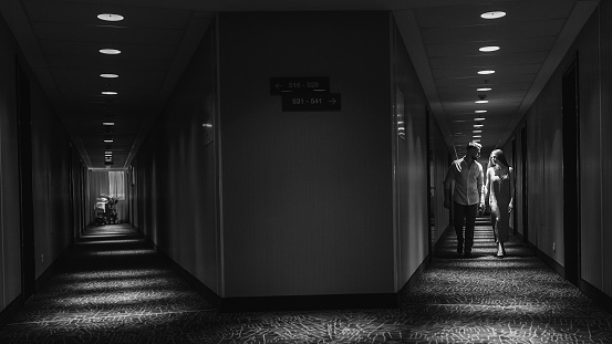 Young couple in love walking along the corridor of the hotel. Black and white