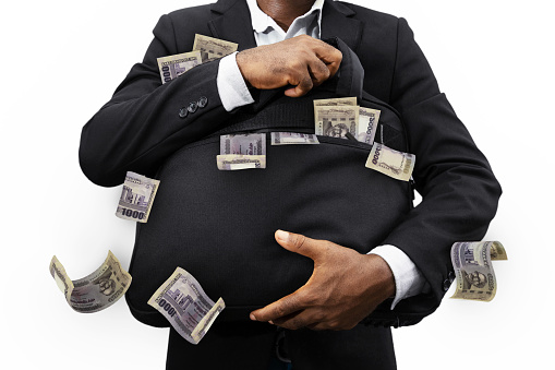 Businessman holding black bag full of 1000 Bangladeshi taka notes isolated on white background, money falling from bag