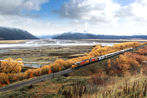 A scenic view of rusty wagons on railroad against mountains in Jasper National Park, Alberta, Canada