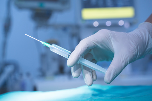 syringe in doctor's hand, ready to inject patient