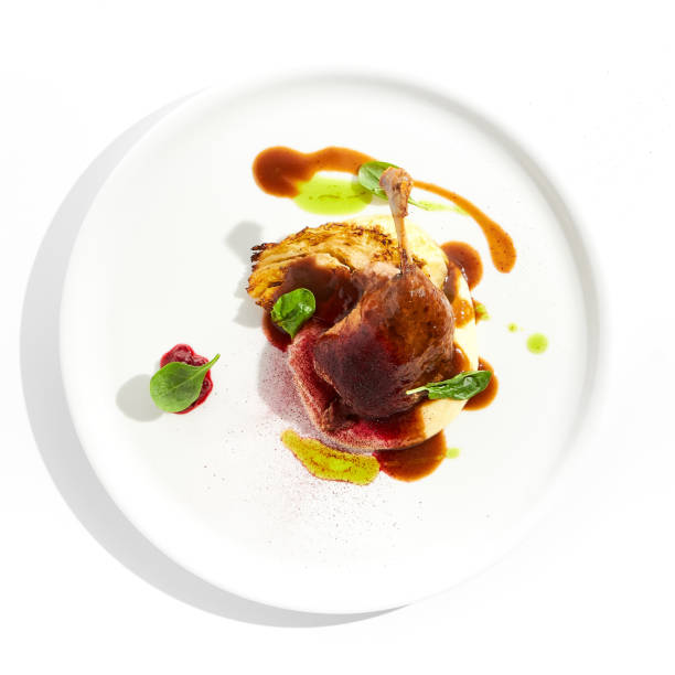 istock Delicatessen dish - duck leg confit with mashed potatoes and cabbage steak. Duck confit with vegetables and wine gravy on white plate. Gourmet meal in restaurant menu. Fusion main course. 1410762609